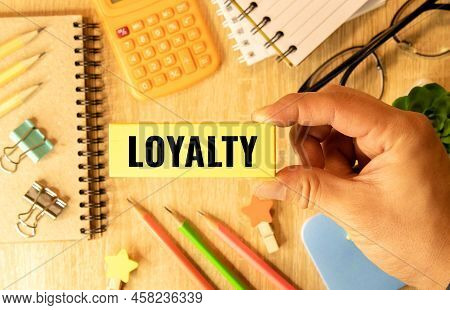 Loyalty Wood Word On Compressed Board With Humans Finger At Y Letter