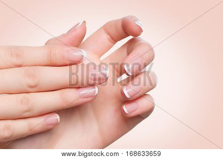 Beautiful Woman Hands. Spa and Manicure concept. Female hands with french manicure. Soft skin, skincare concept. Beauty nails. over beige background