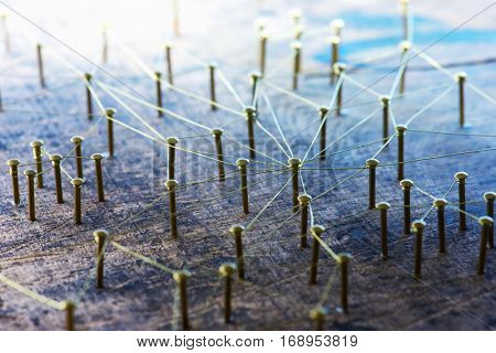 Linking entities. Network, networking, social media, internet communication abstract. Many small network connected to a larger network. Web of gold wires on rustic wood. 