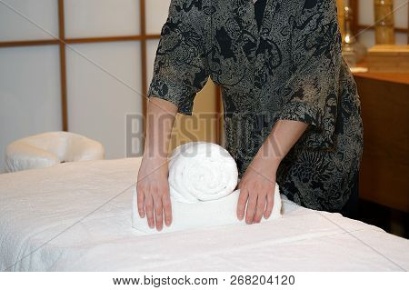 The Girl Prepares A Workplace Massage Bed In The Spa For The Reception Of Clients. The Maid Is Prepa