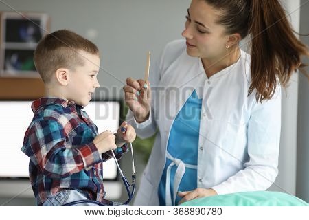 Child Doctors Appointment, Plays With Stethoscope. Family Doctor Helps Child Cope With Fear Being Ex