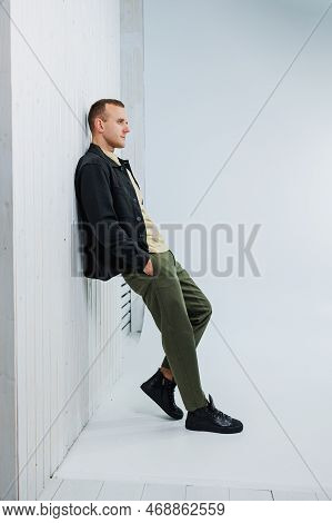 A Young Handsome Man In Casual Clothes Poses On A White Background In The Studio