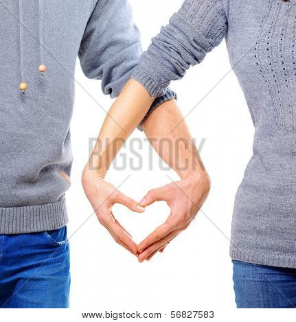 Valentine Couple in love showing Heart with their fingers. Love Concept. Valentines Day. Family with Heart made by their Hands. Young Man and Woman. Love Concept. Heart Sign. Valentines Day 