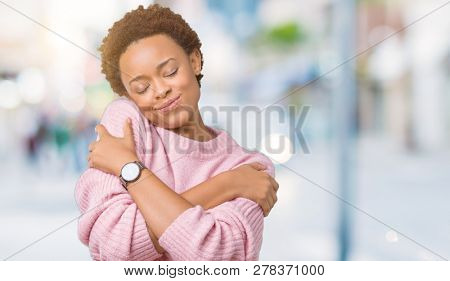 Beautiful young african american woman over isolated background Hugging oneself happy and positive, smiling confident. Self love and self care