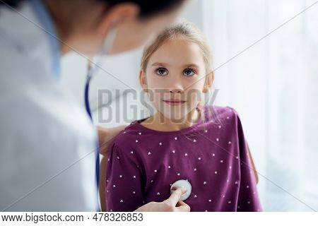 Happy Smiling Child Girl Patient At Usual Medical Inspection. Doctor And Kid Patient At Home. Medici