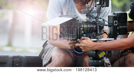 Behind the scenes of movie shooting or video production and film crew team with camera equipment at outdoor location.