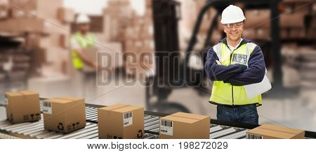 Worker wearing hard hat in warehouse against warehouse worker loading up pallet