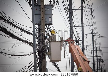 Electricians Wiring Cable Repair Services.
Technician Checking Fixing Broken Electric Wire On Pole.
