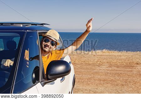 Young Man In A Straw Hat Looking From The Window Of His Car