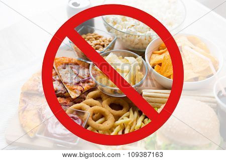 fast food, low carb diet, fattening and unhealthy eating concept -close up of fast food snacks and cola drink behind no symbol or circle-backslash prohibition sign