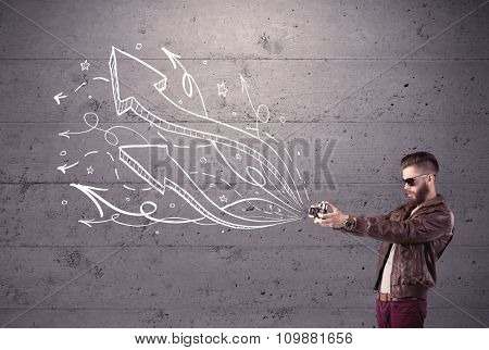 A hipster guy opening his point of view through looking a vintage camera concept with illustratied drawn arrows on urban wall