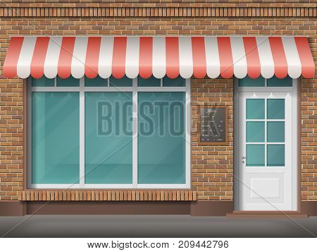 Cafe or store front with large transparent window and awning. Facade of red brick. Empty glass showcase of boutique. Entrance in the small  shop.