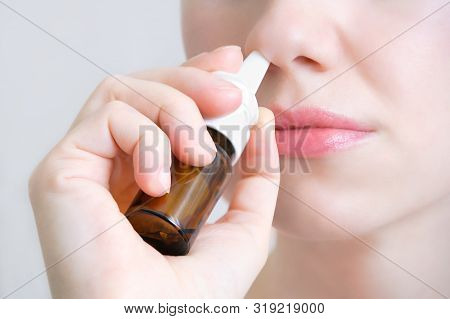 Nasal Spray.  Beautiful Young Woman. Closeup. Face With Nasal Drops. Close-up Of Female Spraying Med