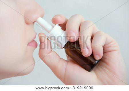 Nasal Spray.  Beautiful Young Woman. Face With Nasal Drops. Close-up Of Female Spraying Medical Nasa