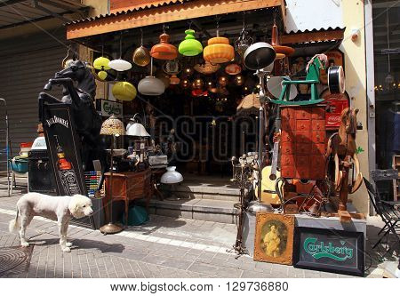 TEL AVIV-YAFO ISRAEL - APRIL 5 2016: Old vintage lamps toys furniture and other staff at entry to antiquities shop at Jaffa flea market in Tel Aviv-Jaffa Israel. Jaffa flea market is popular attractions for tourists and locals.