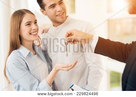 Young Couple In A Meeting With A Realtor. A Guy And A Girl Make A Contract With A Realtor About Buyi