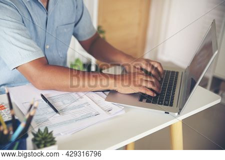 Hand Of Man Using Laptop. Personal Income Tax Return Form Under Us Law Placed On Desk. Accountant Wo