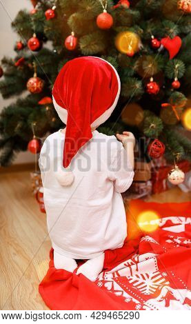 Happy Child Decorating The Christmas Tree With Balls. Christmas Eve Concept. Christmas Decorating. C