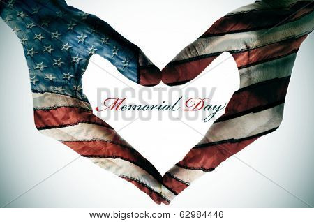 memorial day written in the blank space of a heart sign made with the hands patterned with the colors and the stars of the United States flag