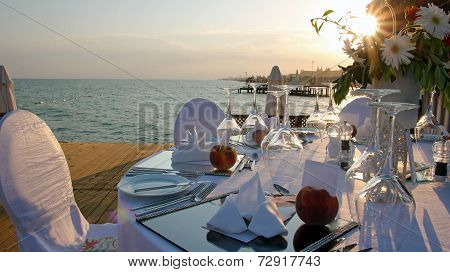 Romantic Table Setting On Pier At Sunset