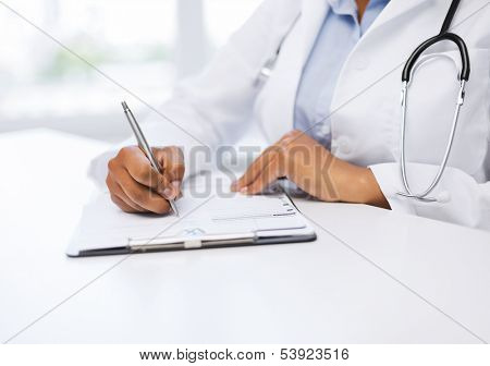 healthcare and medical concept - female doctor writing prescription