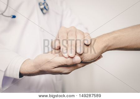 Two people holding hands for comfort vintage tone. doctor's hands holding patient's hand for encouragement and empathy. Doctor man. Doctor woman. Doctor hand. Doctor room. Uniform doctor. Doctor shake hand.