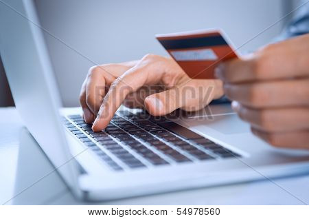 Close Up Of A Man Shopping Online Using Laptop With Credit Card