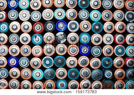 Energy abstract background of colorful batteries. Close up top view on rows of selection of AA batteries. Alkaline battery aa size. Several batteries are next to each other. Many aa batteries.