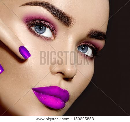 Beauty Brunette Woman with Perfect Makeup. Beautiful Professional Make-up. Red Lips and Nails, perfect eyebrows. Skin care, foundation, contouring. Beauty Girl's Face isolated on black background