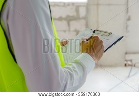 Foreman Builder, Engineer Or Inspector In Green Safety Vest Reflective Checking And Inspecting With 