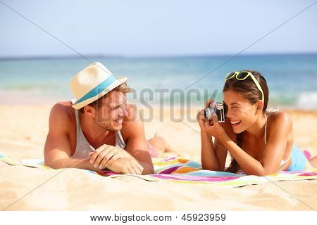 Beach fun paar reizen. Vrouw nemen foto foto van man die lacht blij met retro vintage camera, 