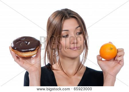 Woman Comparing Unhealthy Donut And Orange Fruit