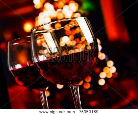 Two Red Wine Glass Against Christmas Lights Decoration Background