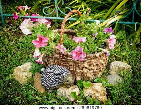 The Design Of The Infield. Basket With Flowers And A Hedgehog Figure.