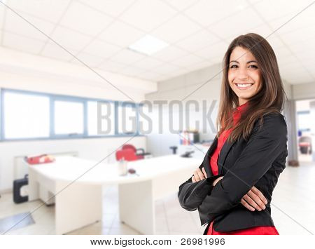 Retrato de uma mulher de negócios jovem bonito, sorridente, em um ambiente de escritório