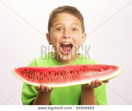 Funny and happy little boy eating watermelon.Little boy holding a big watermelon.