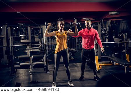 Shape Motivated Attractive Muscular Fitness Woman Standing With Dumbbells Above And Doing A Shoulder