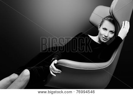 Portrait of a stunning fashionable model sitting in a chair in Art Nouveau style. Business, elegant businesswoman. Interior, furniture.