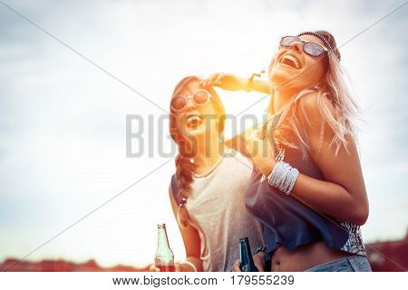 Happy friends laughing and having fun outdoors at concert