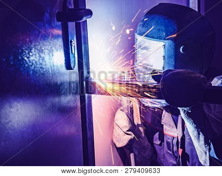 Welder Worker Performs Jump Welding. Worker Welder Performs Arc-welding Process Of Metal Structures.