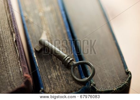 Knowledge, concept image. key to solutions. Old vintage key on old books.