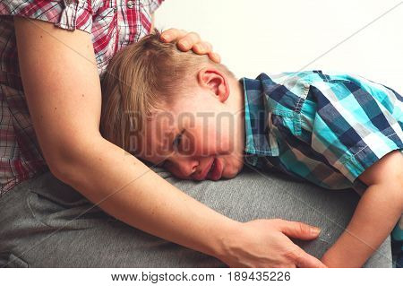 Crying unhappy boy hugging his mother. Mom comforting little child after sorrow. Family relations problems.