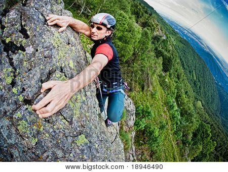 山、岩登りの極端なスポーツ、夏のシーズンの急な壁を登る若い白人男性。ホリゾント