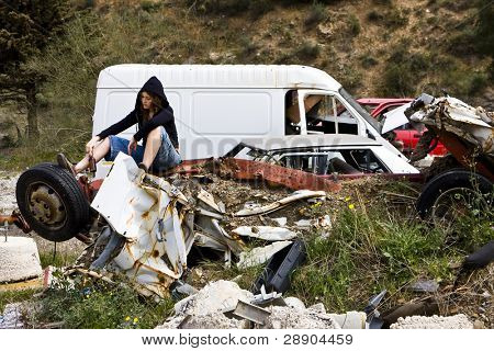 Young woman taking beer in the scrapyard