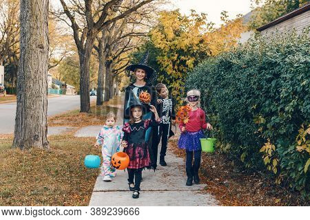 Trick Or Treat. Mother With Children Going To Trick Or Treat On Halloween Holiday. Mom With Kids In 