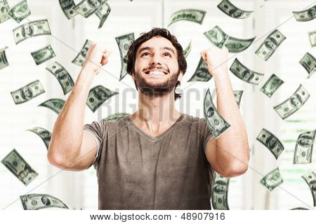 Retrato de um jovem muito feliz em uma chuva de dinheiro