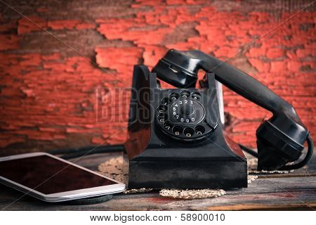 Old Rotary Telephone Alongside A Tablet Computer