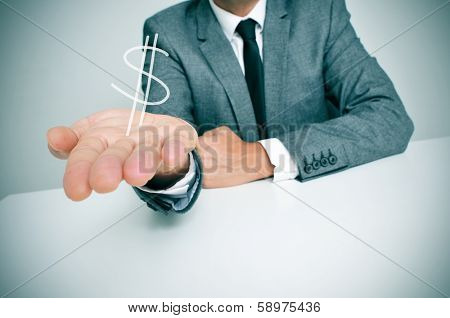 a businessman sitting in a desk showing a drawn dollar sign in his hand