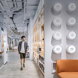 A person walking in a room with white walls and white circles.