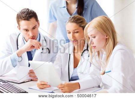 healthcare, medical and technology concept - group of doctors looking at tablet pc